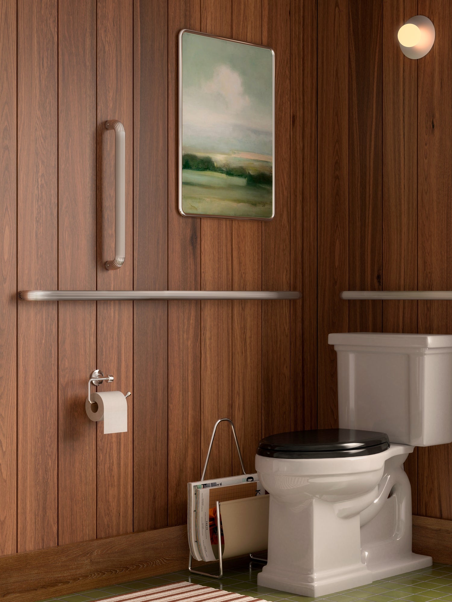 Polished nickel Remsen grab bars mounted on walnut paneling beside a toilet, with framed landscape art and a wall sconce